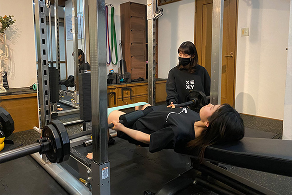 パーソナルトレーニングを受ける30代女性の様子