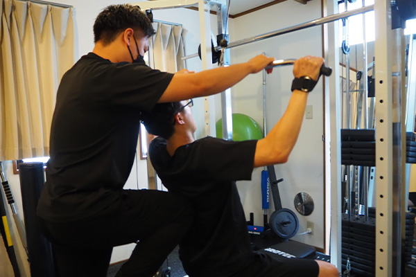 パーソナルトレーニングを受ける30代男性の様子