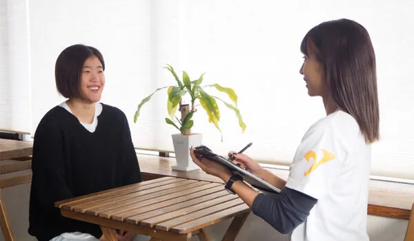 住吉のパーソナルジムに在籍するトレーナーによるカウンセリングを受ける30代の女性